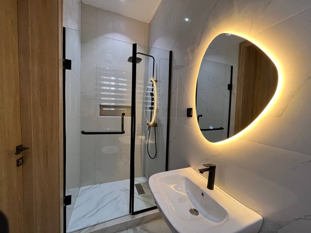En-suite bathroom with illuminated mirror, Apartment Alpha, Nimbus Nook Ikeja GRA