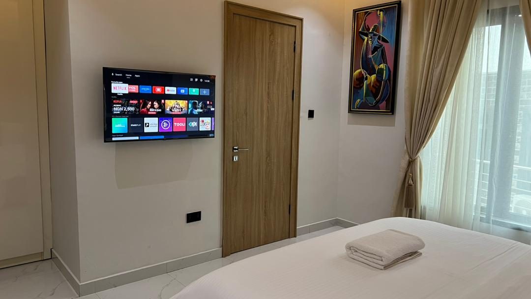 Second bedroom with smart TV and artwork, Apartment Charlie, Nimbus Nook Ikeja GRA