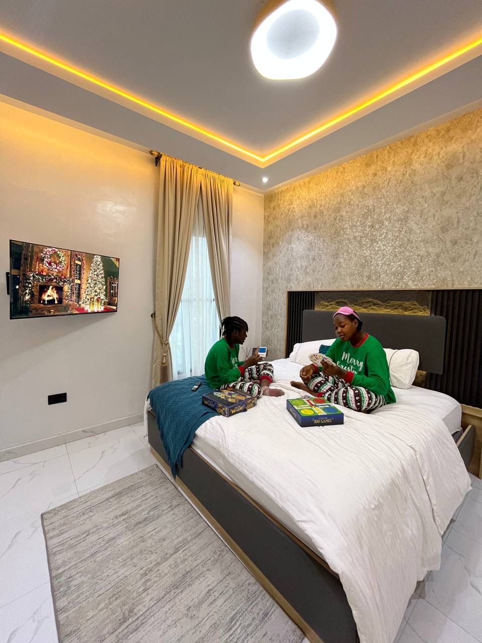 Girls playing cards on the bed in a warmly lit Nimbus Nook bedroom