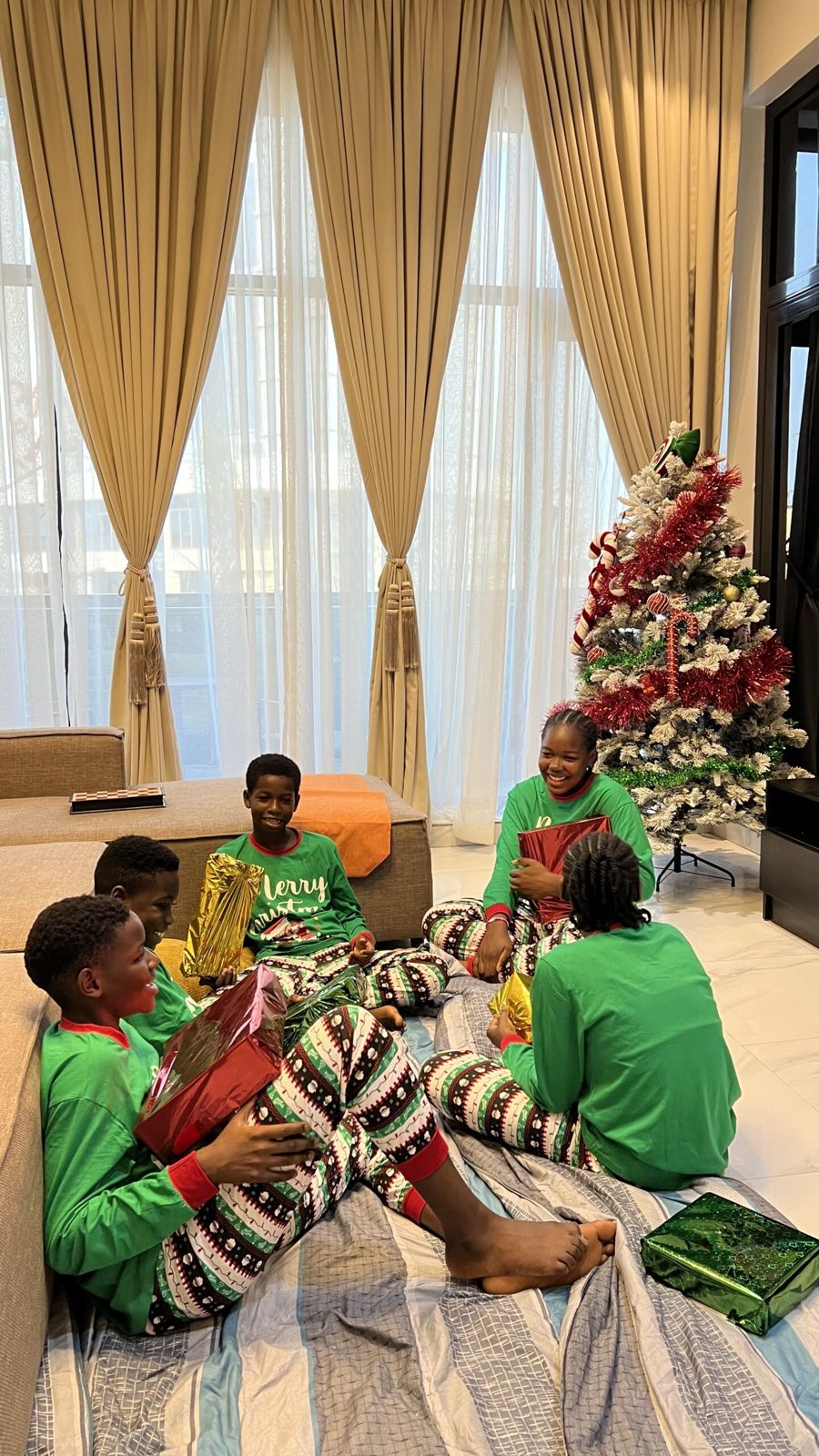 Children opening presents by the Christmas tree in a Nimbus Nook living room