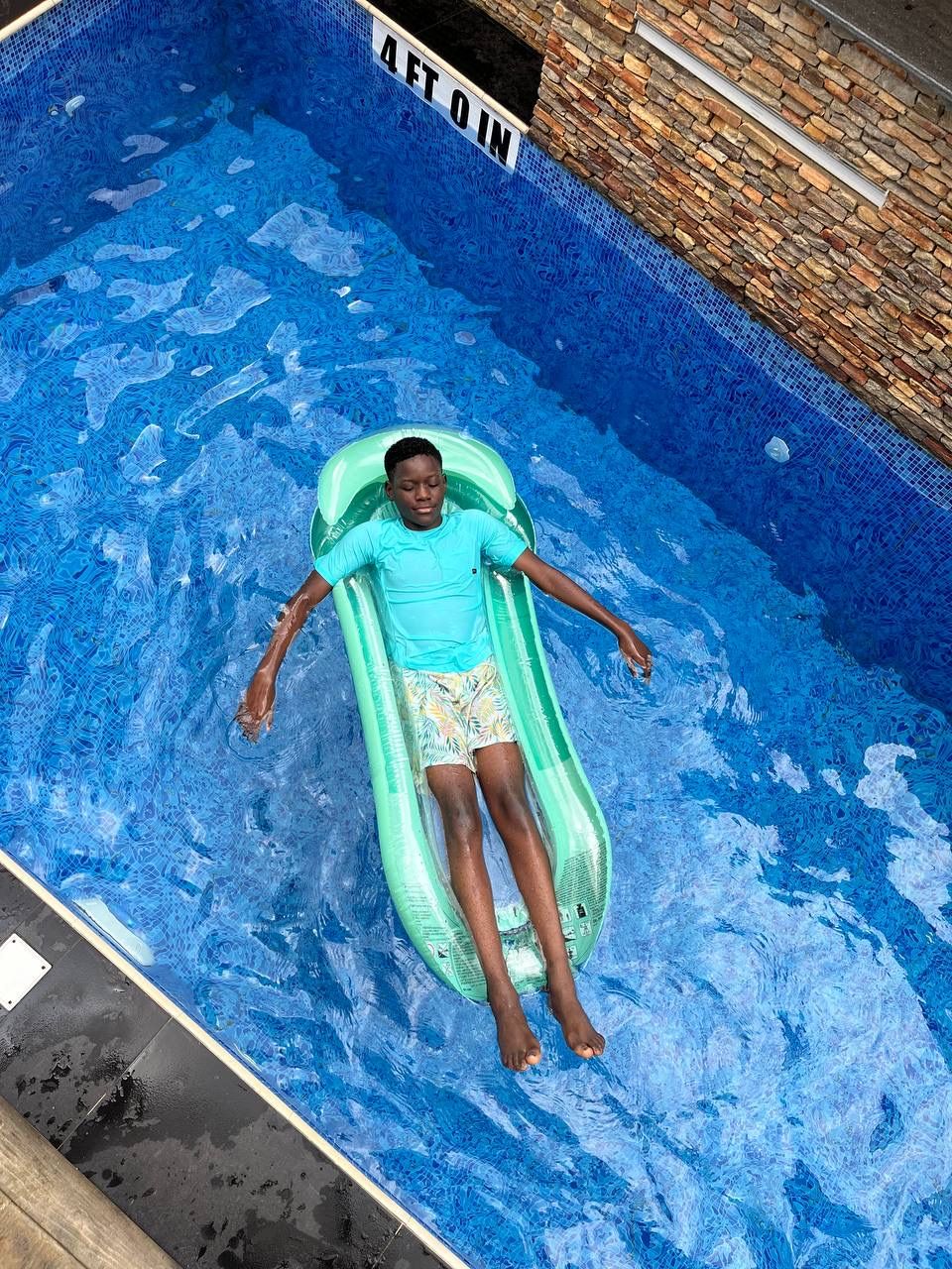 Child relaxing on a pool float at Nimbus Nook, Ikeja GRA